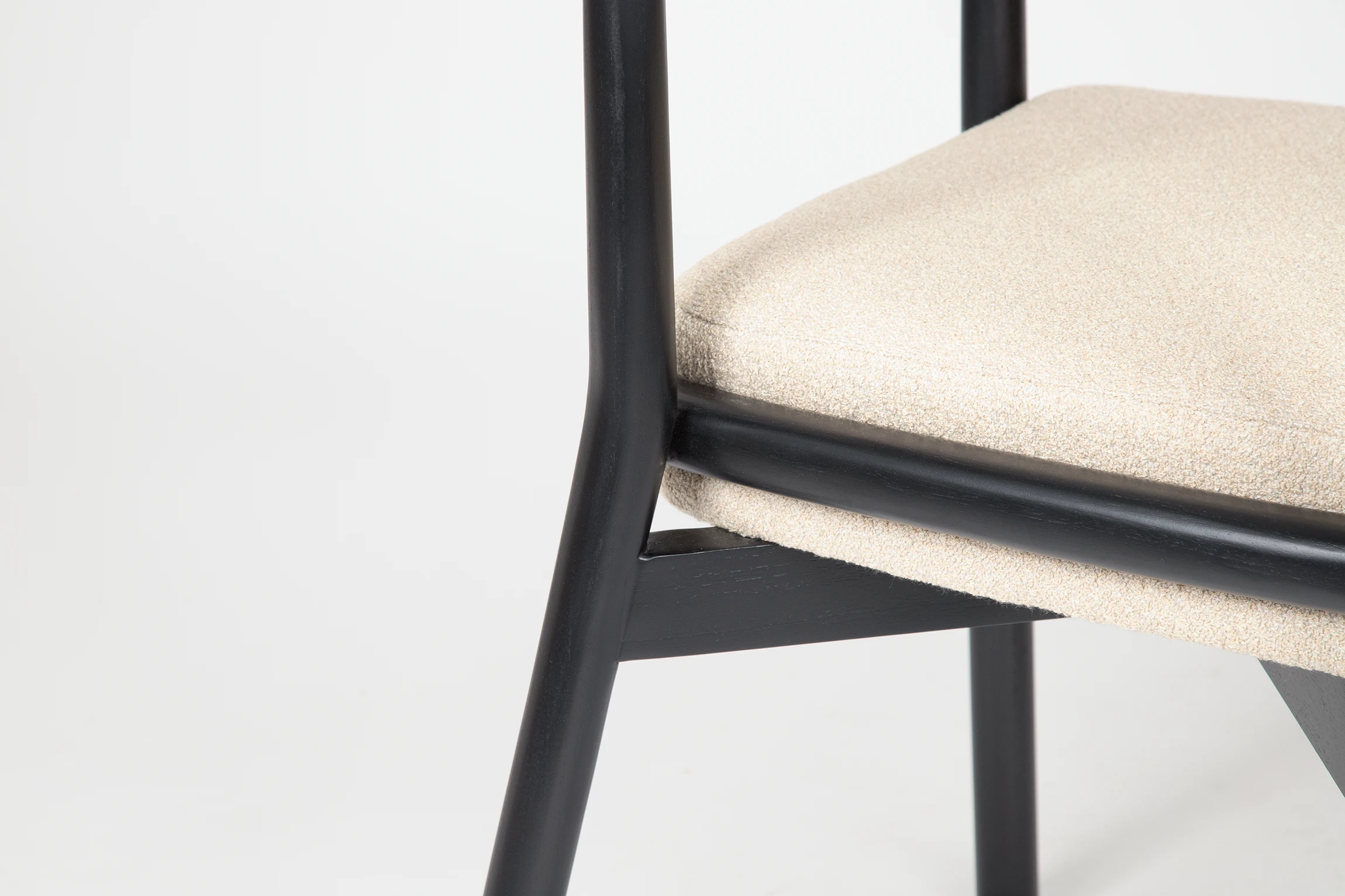 MOON dining chair made of teak with a ivory fabric upholstered seat in close up leg view