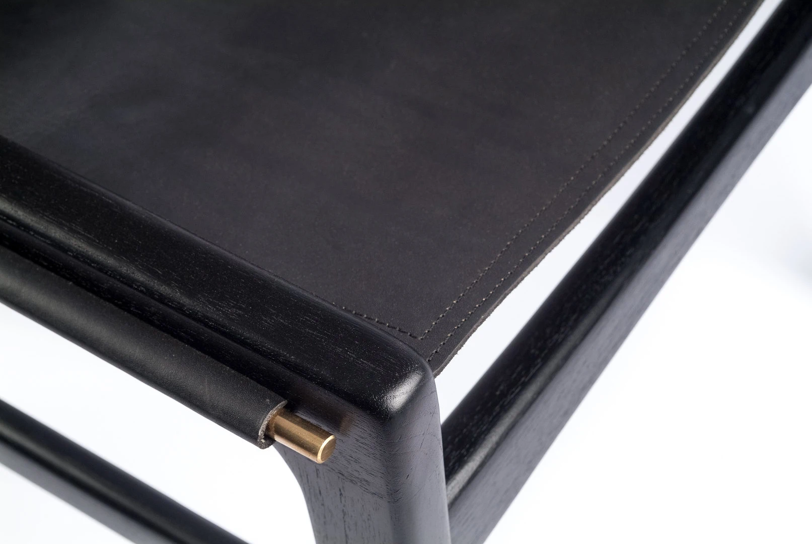 TOKYO dining chair made of black teak with continuous black leather seat and backrest in close up view