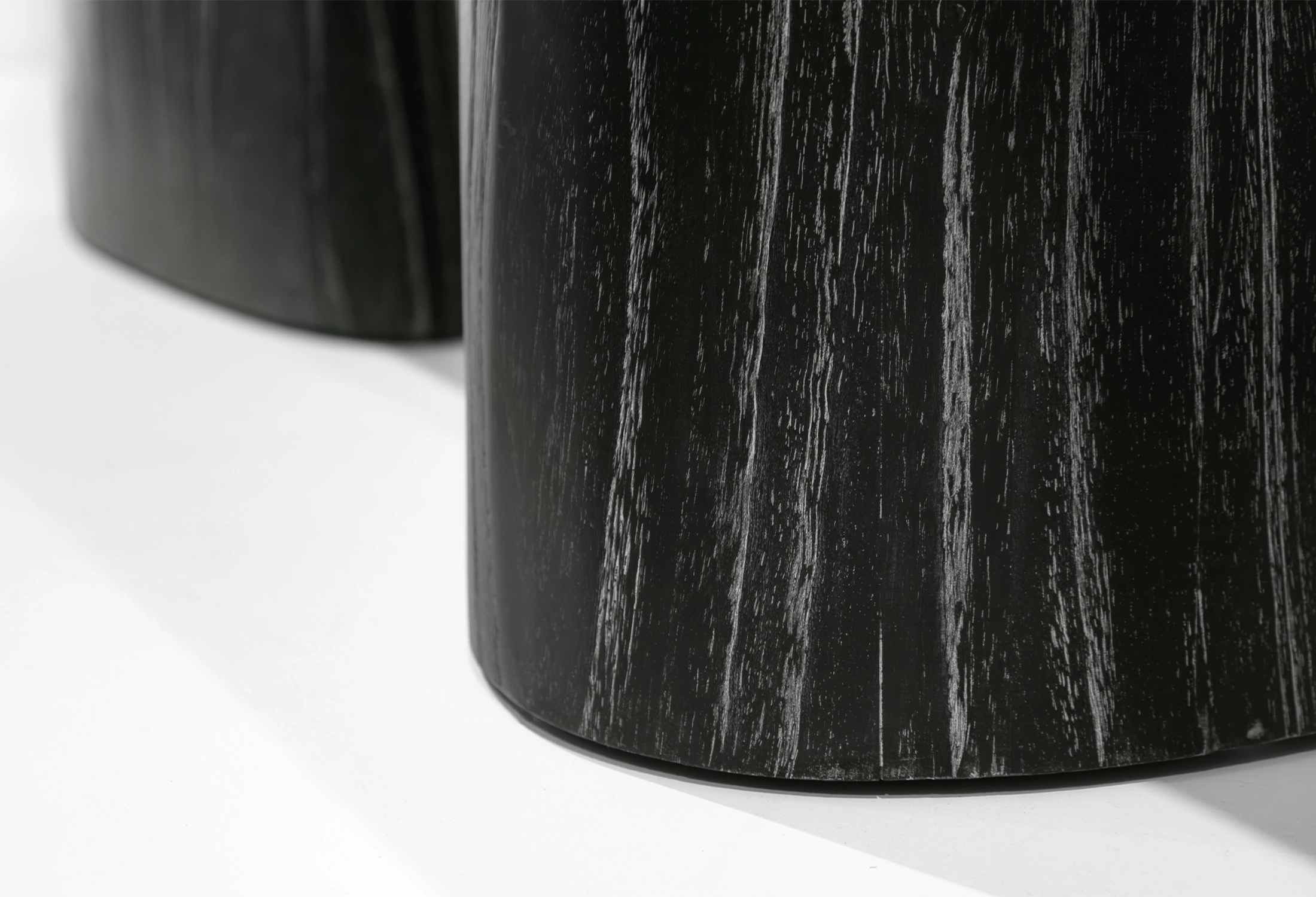 Close-up of MARINA console table's round leg, made of black Java oak